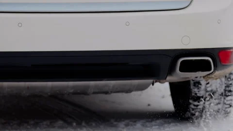 Close-up image of the winter tires of the car that drives through the snow and Stock Footage 305675818