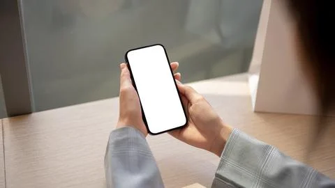 Close-up image of a woman using her smartphone at a table indoors. a white-.. Stock Illustration