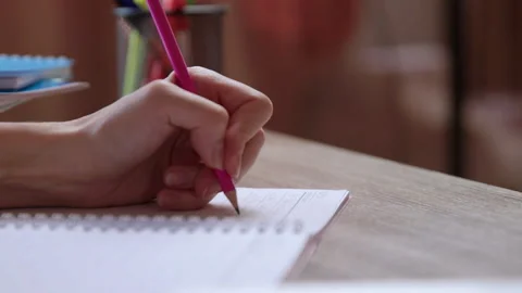 Close-up image of a woman's hand making notes in a notebook with a pencil. Video stock 304931903