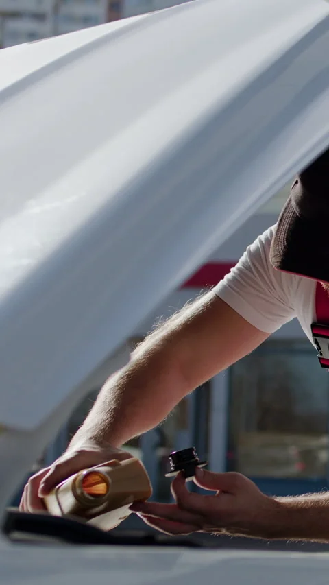 Close-up image of a worker from a car service pouring oil for cars. Worker Stock Footage 276262011