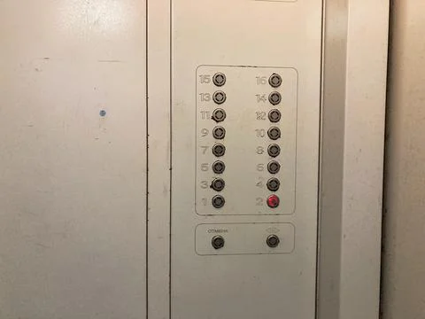 Close-up image of an worn metallic elevator control panel with buttons rangin Foto stock
