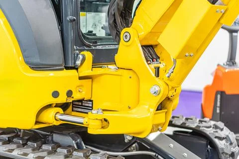 Close-up image of a yellow backhoe loader, focusing on the attachment point w Stock Photos