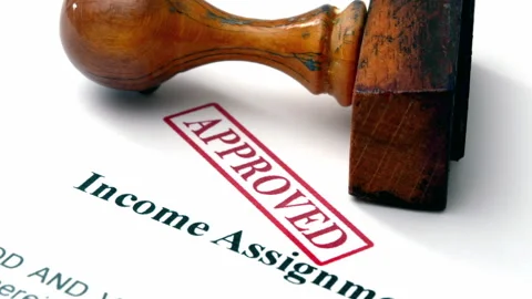 Close up of income assignment stamp approved Stock Footage 345536037