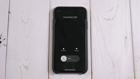 Close-up of an incoming call on the phone screen on a light wooden background Stock Footage 195162568