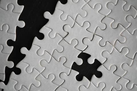 Close-Up of Incomplete Jigsaw Puzzle with Missing Pieces on Dark Background Foto stock