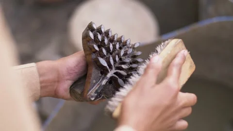 Close up of Indian boy cleaning hand carved wooden stamps for block printing. Stock Footage 151904353