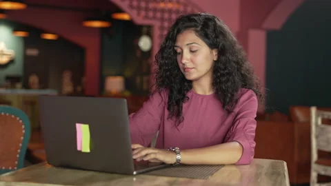 Close up Indian girl sitting on using laptop for chatting with friends at cafe. Stock Footage 232581935