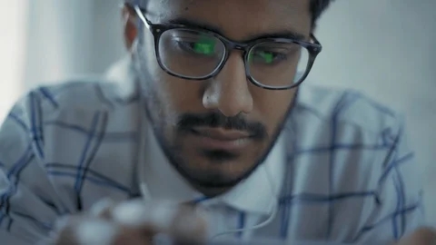 Close-up, Indian Guy with Glasses is Watching a Video with Headphones on your Video stock 111073375