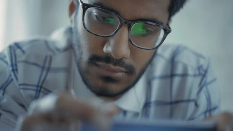 Close-Up, Indian Guy with Glasses Watching Music Video in Headphones on Stock Footage 111074525
