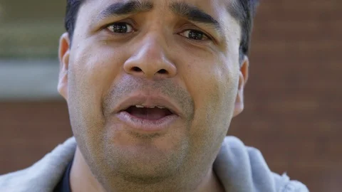 Close Up - Indian man cries into the camera hopelessly - Slow Motion - shot on Stock Footage 125089335