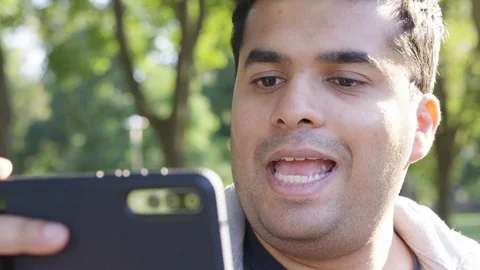 Close Up - Indian man directs as he looks at his phone to take a picture - Slow Stock Footage 125091953
