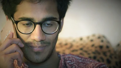 Close-up, Indian Man In Glasses Talking On Phone Sitting At Home On Sofa Stock Footage 90876223
