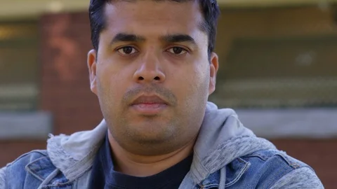 Close Up - Indian man looks into the camera, sad and disappointed - Slow Motion Stock Footage 125088105
