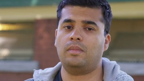 Close Up - Indian man looks into the camera, sad and vulnerable - Slow Motion - Stock Footage 125088160