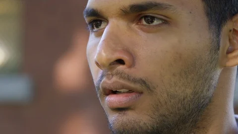 Close Up - Indian man looks off camera, frustrated and flustered - Slow Motion - Stock Footage 125088974