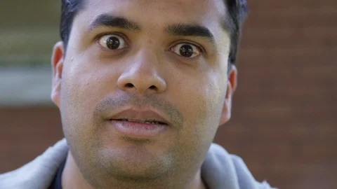 Close Up - Indian man shouts into the camera negatively - Slow Motion - shot on Stock Footage 125089732