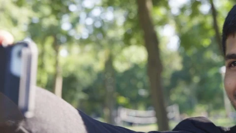 Close Up - Indian man smiles while he frames and takes a picture at the park - Stock Footage 125092544