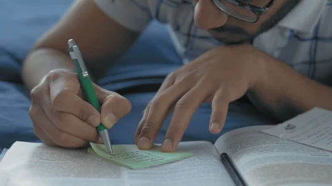 Close-Up, Indian Student in Glasses Makes Records in a Crib Lying on a Bed Stock Footage 108103294