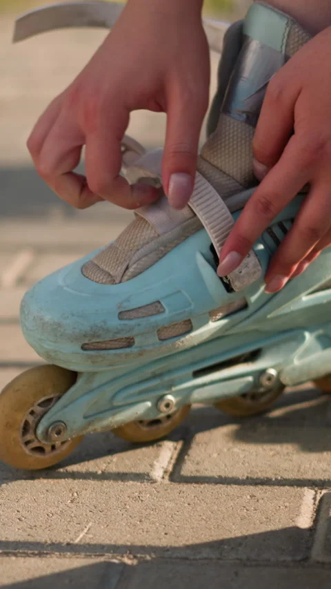 Close-Up of Individual Adjusting Strap on Roller Skate Under Sunlight with Stock Footage 310521289