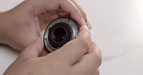 Close-up of an individual holding a camera lens while checking it Stock Footage 285879469