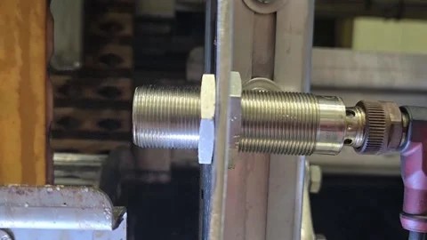 Close-up of an inductive proximity sensor detecting a metal part on an industria Video stock 330972430