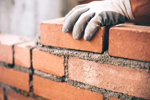 Close up of industrial bricklayer installing bricks on construction site Stock Photos