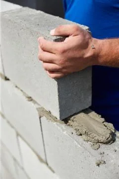 Close up of industrial bricklayer installing bricks on construction site 库存照片