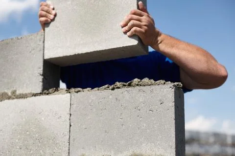 Close up of industrial bricklayer installing bricks on construction site Stock Photos