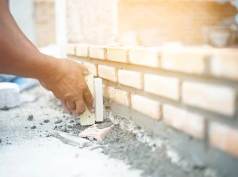 Close up of industrial bricklayer installing bricks on construction site Stock Photos