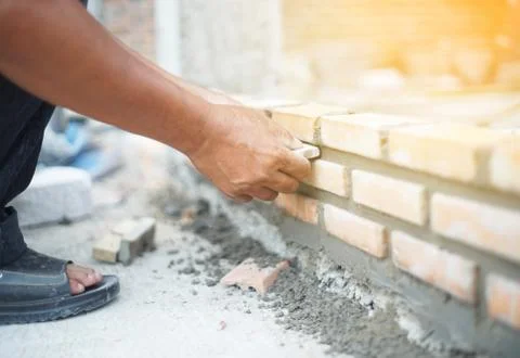 Close up of industrial bricklayer installing bricks on construction site Stock Photos