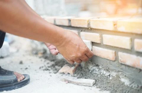 Close up of industrial bricklayer installing bricks on construction site Stock Photos