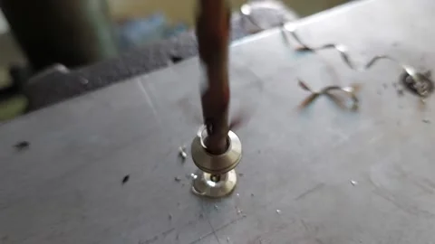 Close-up of an industrial drill press drilling a hole in metal plate Stock Footage 336461614