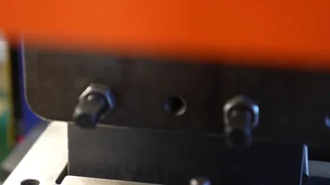 Close-up of industrial hydraulic press die block with orange safety cover in Stock Footage 336637366