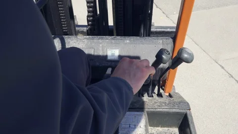 Close up industrial worker operating and driving forklift with his hand Stock Footage 130165677