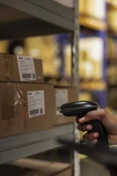 Close up of industrial worker scanning parcel details using tracking software Stock Photos