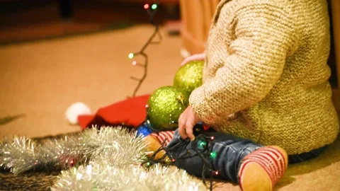 Close-up infant boy playing with Christmas balls. kid's arms holding balls Stock Footage 166035994