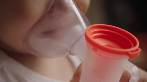 Close-up of Infant Using Nebulizer Mask for Inhalation Treatment Stock Footage 339078205