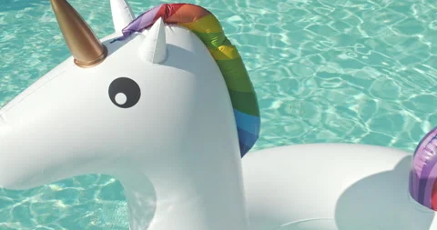 Close-up Inflatable Circle Unicorn Floats in Outdoor Infinity Swimming Pool on Video stock 203906936