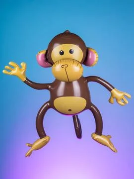 Close-up of an inflatable monkey toy on a purple background, highlighting its Stock-Fotos