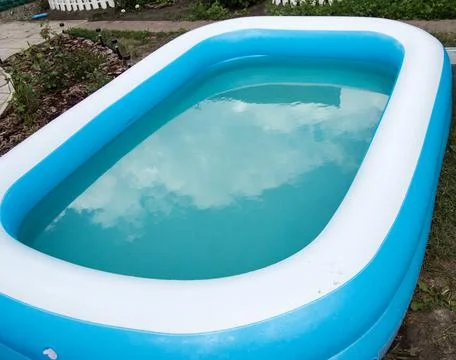 Close-up of an inflatable pool standing on the grass on a sunny summer day, t Stock Photos