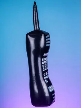 Close-up of an inflatable retro black mobile phone toy on a purple background Stock Photos