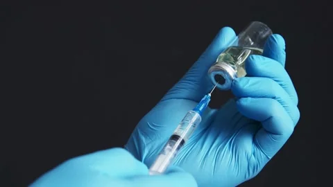 Close Up of injection liquid being in syringe. medical mask and blue gloves Stock-Footage 336586882