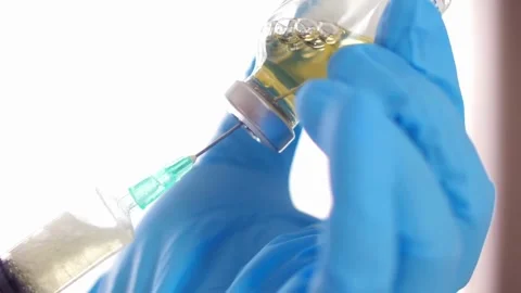 Close Up of injection liquid being in syringe. medical mask and blue gloves Stock-Footage 336587041