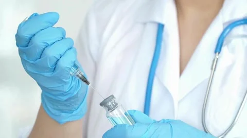 Close Up of injection liquid being in syringe. medical mask and blue gloves Stock Footage 336587198