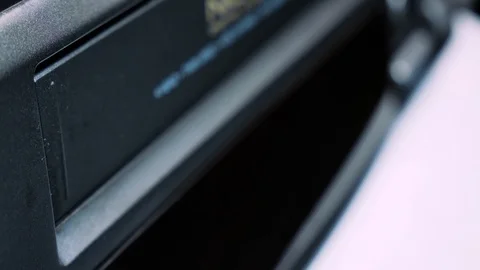 Close-up insert a vintage VHS video cassette tape into the recorder VCR 4k Stock Footage 123458493