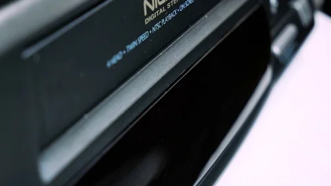 Close-up insert a vintage VHS video cassette tape into the recorder VCR 4k Stock Footage 123458494