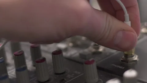 Close up on inserting and removing a headphone cable from a analog audio mixer Stock Footage 235619489