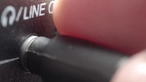 Close Up of Inserting Audio Jack into Line Out Port on Electronic Device in Stock Footage 340179596
