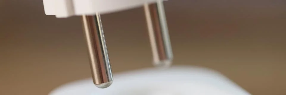 Close-up of inserting electric plug into socket. Stock Photos