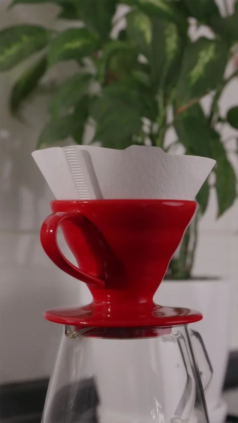 Close-up of inserting paper filter into red coffee dripper Stock Footage 332720160